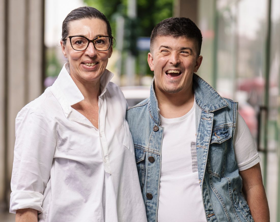 Una educatrice e un ragazzo del progetto sorridono insieme per strada a Milano